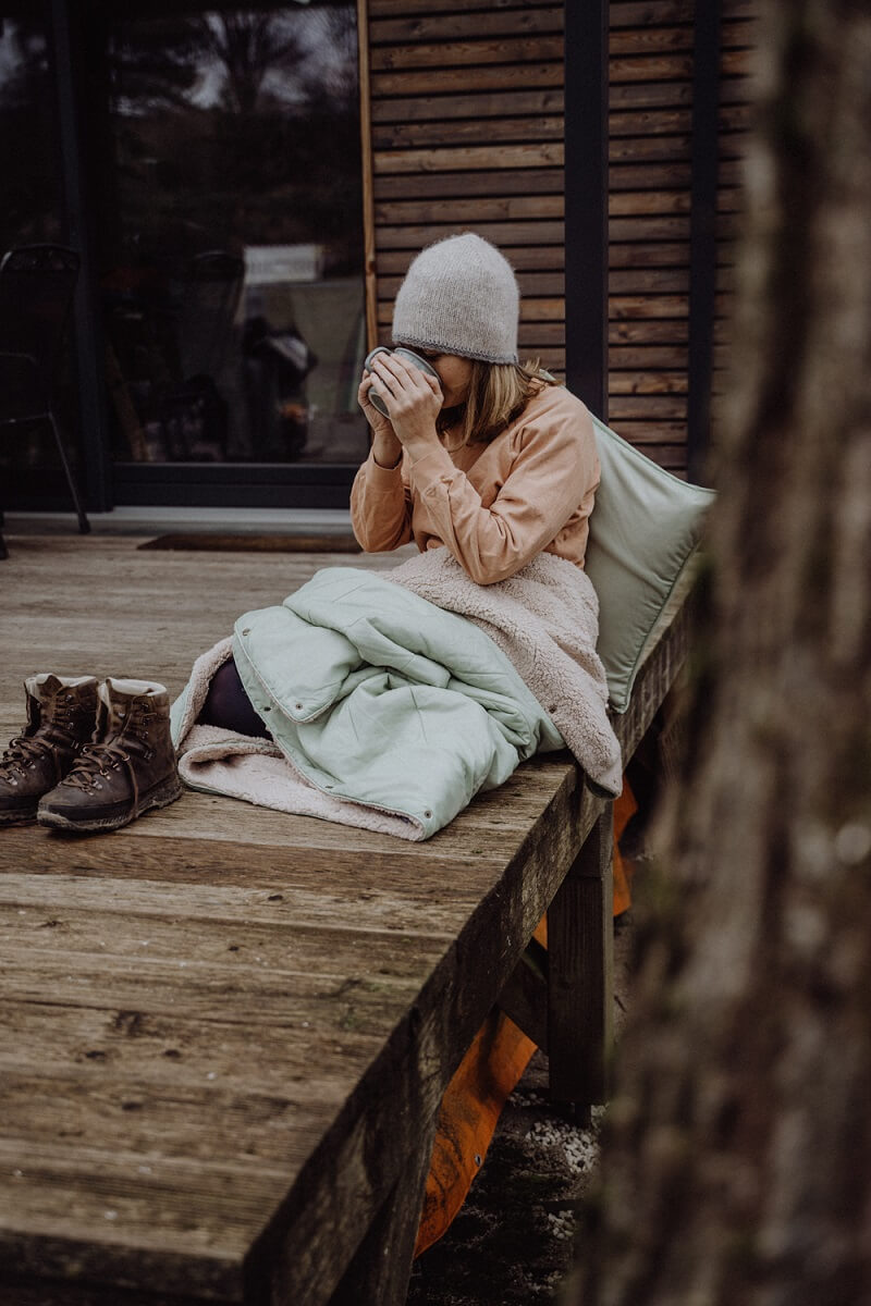 Die Unfold Kuscheldecke in Salbei ist ein leichter und warmer Begleiter für die Reisen im Wohnmobil oder Wohnwagen | Jetzt kaufen bei Wildnest Glamping